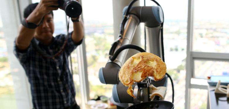 A-robot-performs-making-an-omelette-during-an-exhibition-at-the-CP-All-Acadamy-in-Bangkok