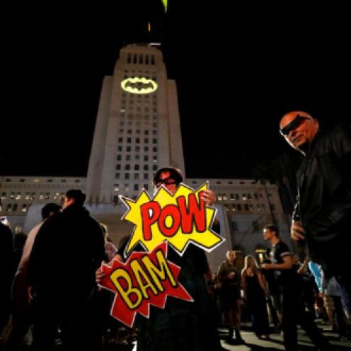 Enthusiasts Cleeland and de Felicis pose as a bat-signal is projected on City Hall in honor of late actor Adam West in Los Angeles