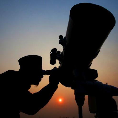 An official looks through a telescope for the sighting of the new moon for the start of the Muslim fasting month of Ramadan at a religious boarding school in Jakarta